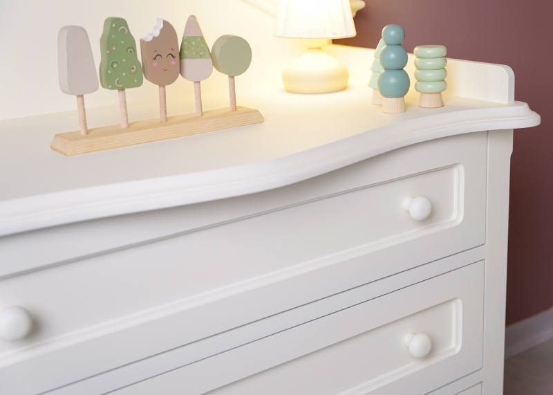 نمای نزدیک از دراور سه کشوی سرویس خواب روژان با دستگیرههای گرد و عروسکهای چوبی تزئینی