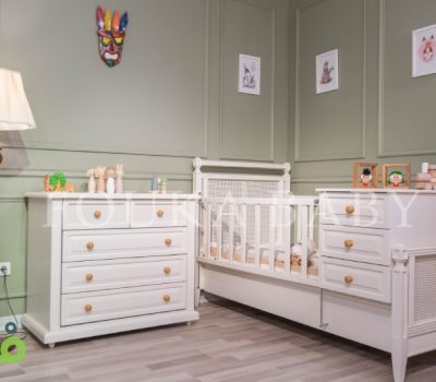 تخت دو منظوره نوزاد و دراور کنار آن از سرویس آیریس به رنگ کرم با بافت حصیری در اتاق سبز روشن