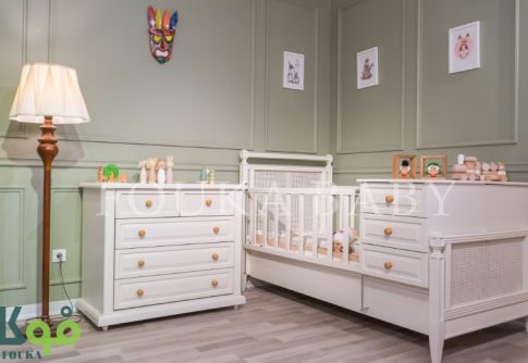 تخت دو منظوره نوزاد و دراور کنار آن از سرویس آیریس به رنگ کرم با بافت حصیری در اتاق سبز روشن